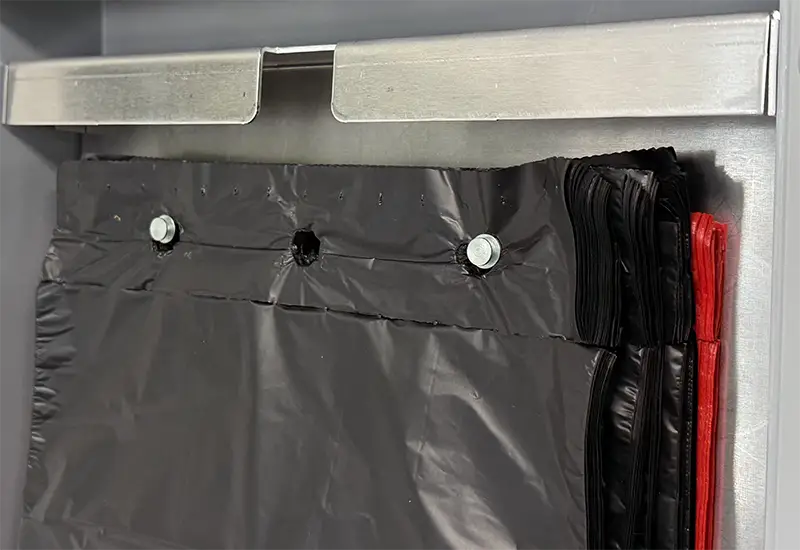 Interior of the distributor Liumings of black and red canine bags stacked in a canine dispenser.