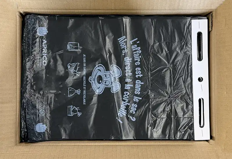 Conditionnement des liasses de sachets canins Conditionnement de liasse de sachets canins noir dans le carton.