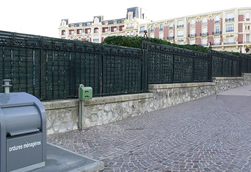 Distributeur double rouleaux sur mât Distributeur canin double rouleaux sur mât dans un espace public.