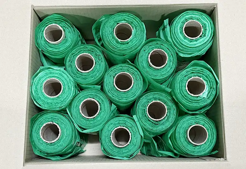 Emballage des rouleaux bio Rouleau de sachets canins biodégradable verts dans un carton.