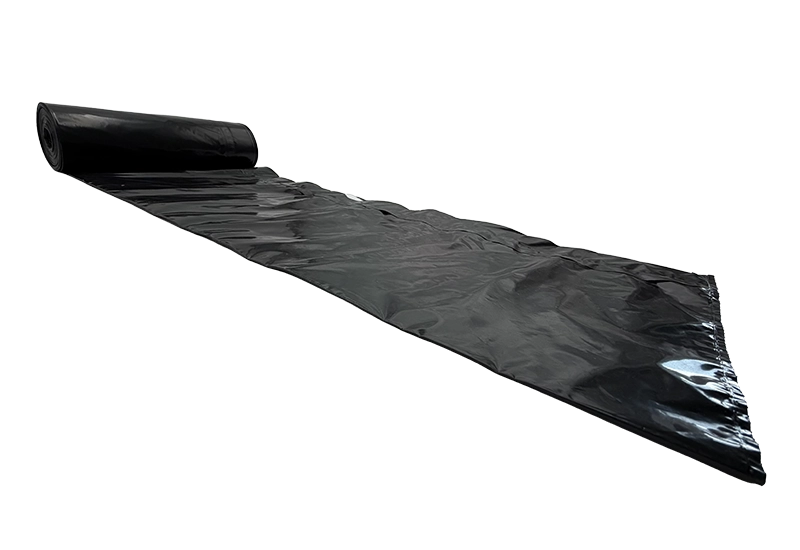 Sacs poubelles noirs Rouleau déplié de sacs poubelles noirs sur fond blanc.