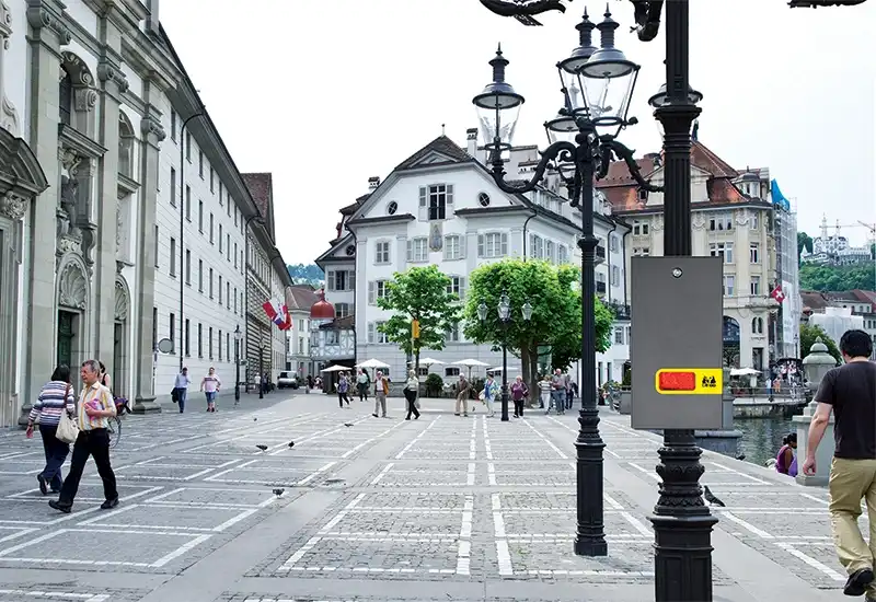 Distributeur à caca de chien en liasse gris Distributeur canin en acier gris sur un lampadaire dans une rue d'une grande ville.